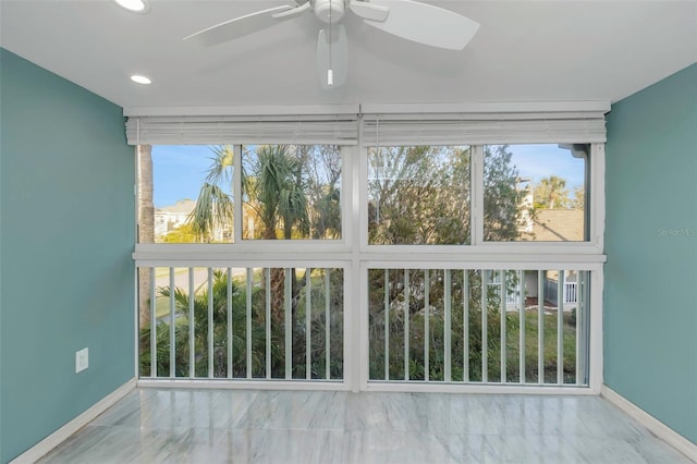 unfurnished sunroom with ceiling fan