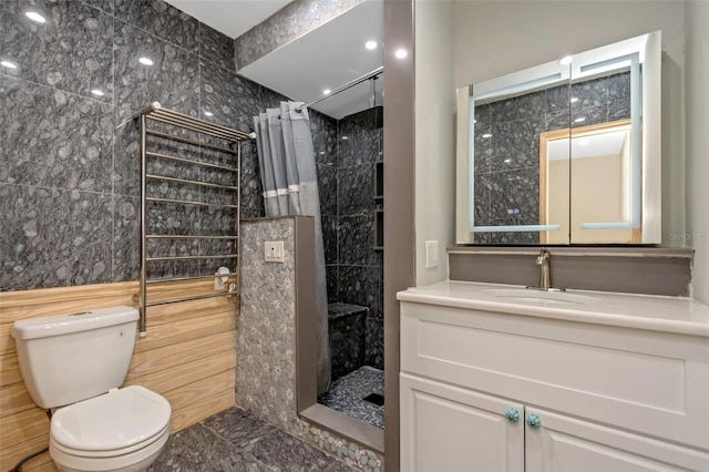 bathroom featuring toilet, tile walls, vanity, and walk in shower