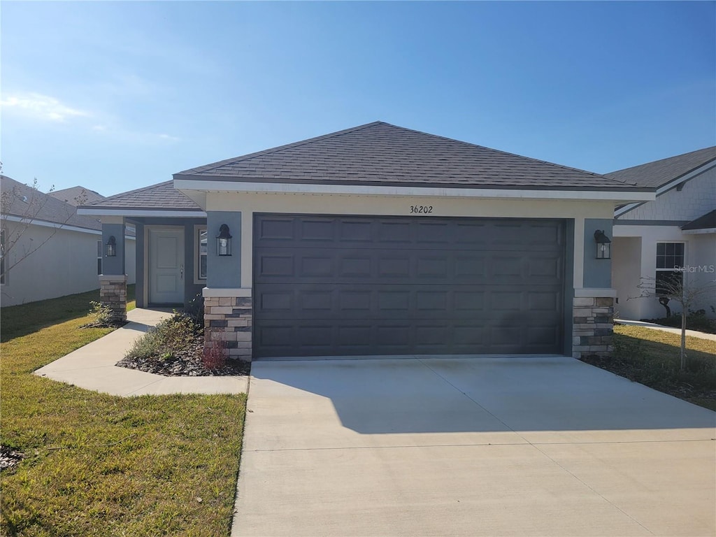 view of front of home featuring a garage and a front yard