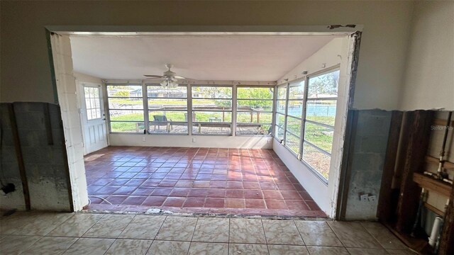 unfurnished sunroom with ceiling fan