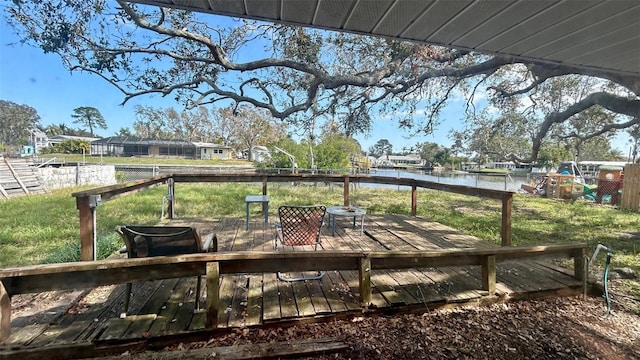 deck featuring a water view and a lawn