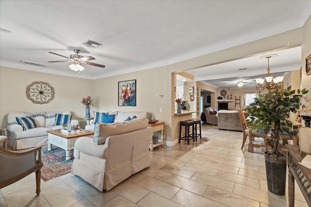 living room featuring ceiling fan with notable chandelier