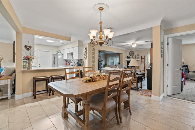 tiled dining room with crown molding and ceiling fan with notable chandelier