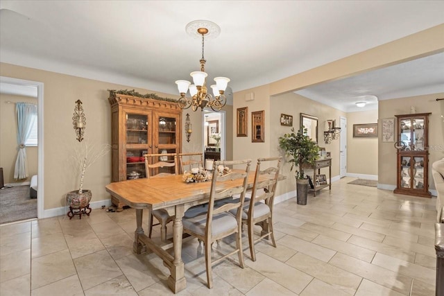 tiled dining space featuring a chandelier