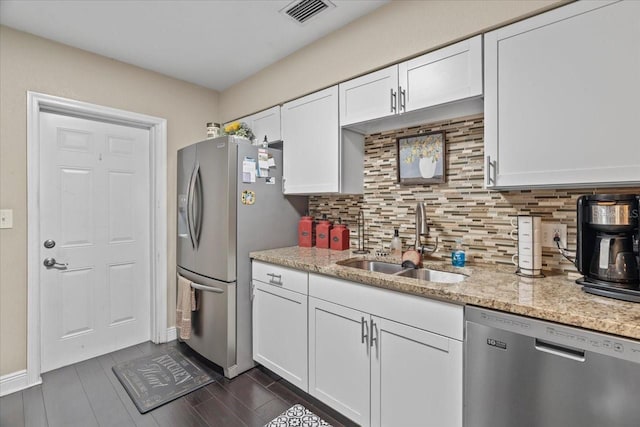 kitchen featuring white cabinetry, appliances with stainless steel finishes, sink, and light stone counters