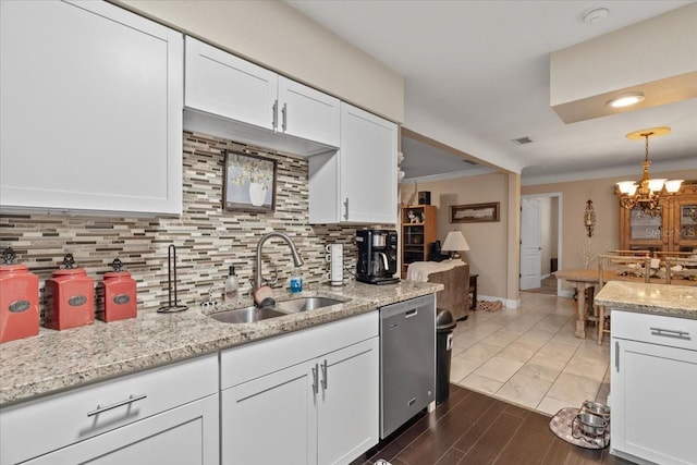 kitchen featuring white cabinetry, decorative light fixtures, dishwasher, and sink