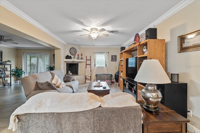 living room with crown molding, ceiling fan, and a brick fireplace