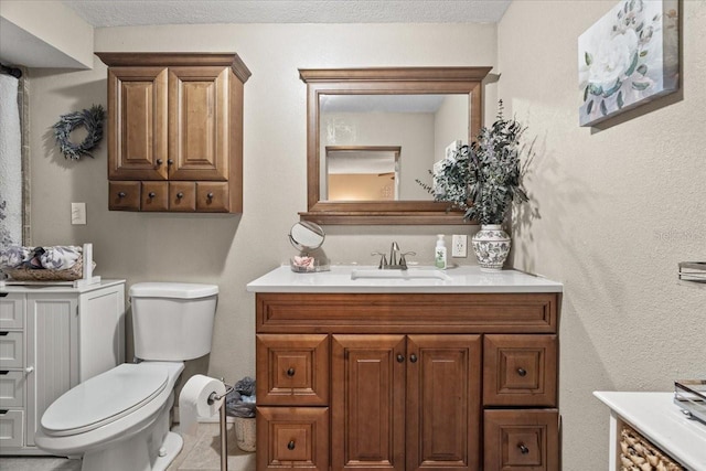 bathroom with vanity, a textured ceiling, and toilet