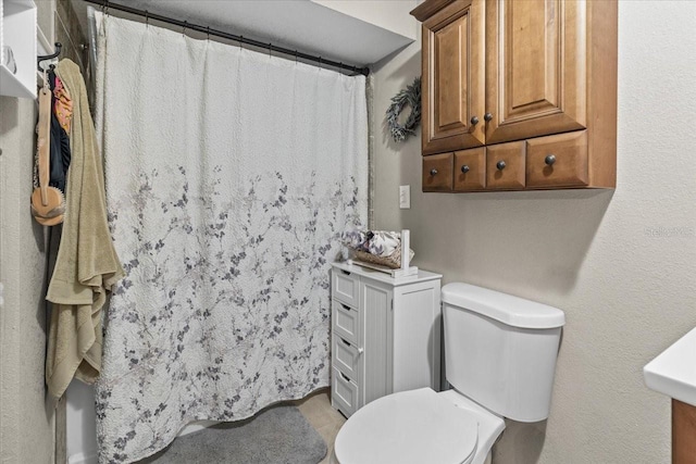 bathroom with curtained shower and toilet