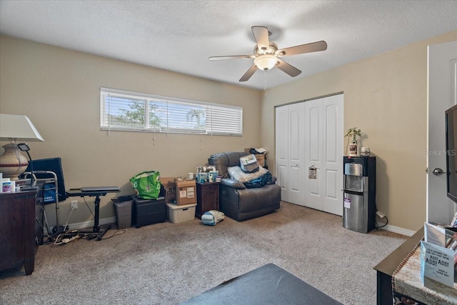 interior space with ceiling fan, carpet, and a textured ceiling