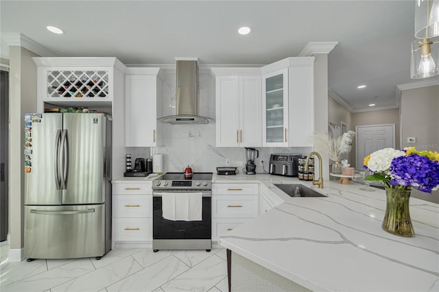 kitchen with crown molding, light stone countertops, appliances with stainless steel finishes, wall chimney exhaust hood, and a sink