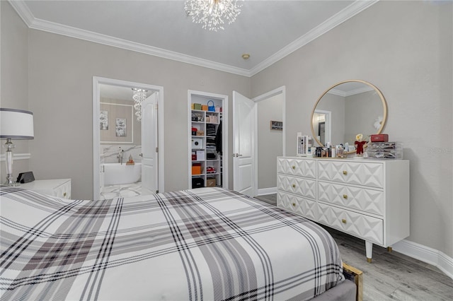 bedroom with a spacious closet, crown molding, baseboards, an inviting chandelier, and wood finished floors