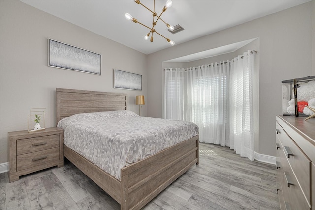 bedroom featuring visible vents, baseboards, a notable chandelier, and light wood finished floors