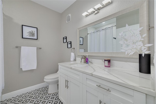 bathroom featuring vanity, a shower with shower curtain, toilet, and baseboards