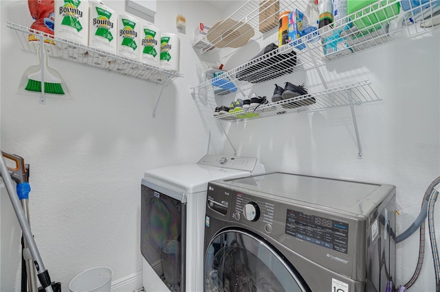 laundry room with laundry area, washer and dryer, and baseboards