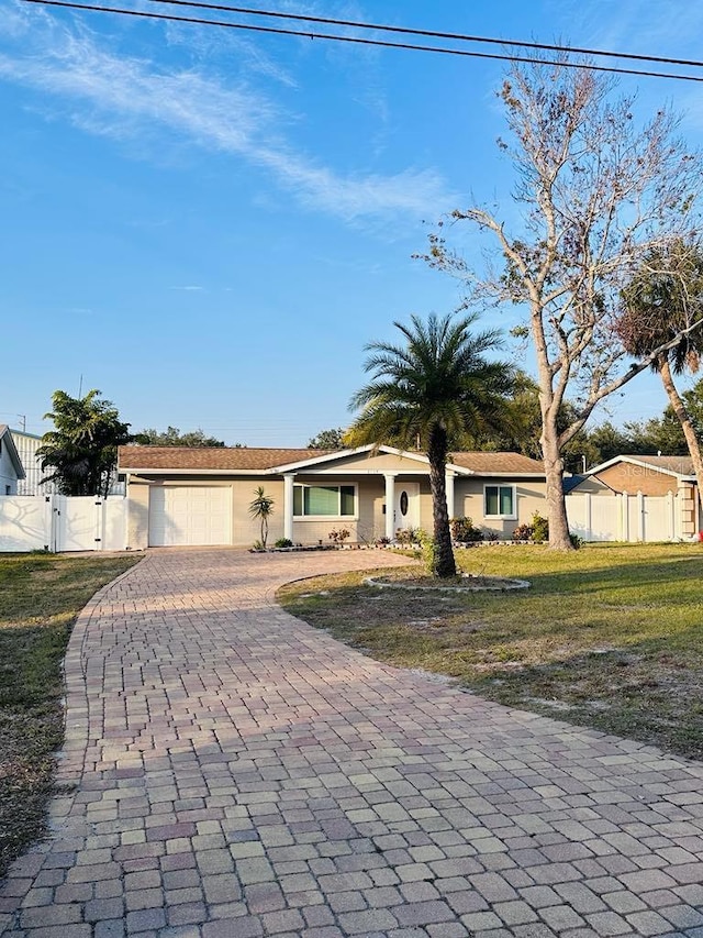 single story home with a garage and a front lawn