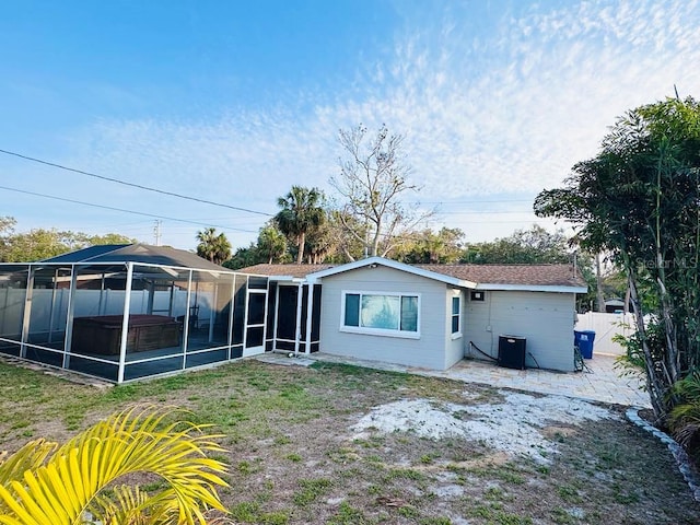 back of house with a hot tub and a patio