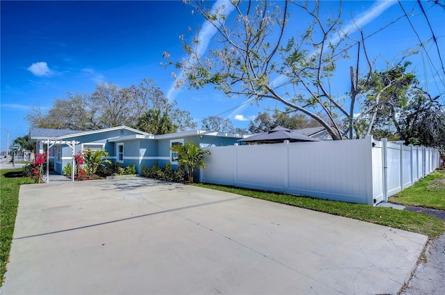 view of property exterior featuring driveway and fence