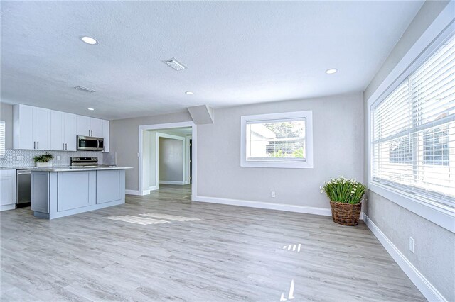 kitchen with light countertops, visible vents, appliances with stainless steel finishes, light wood-style floors, and white cabinets