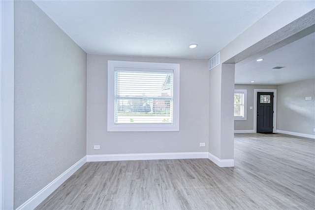 spare room with light wood-type flooring, visible vents, baseboards, and recessed lighting