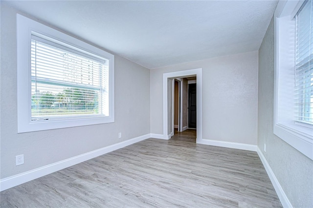 empty room featuring wood finished floors and baseboards