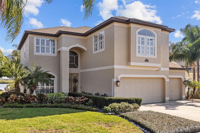 mediterranean / spanish-style house featuring a garage, driveway, a front yard, and stucco siding