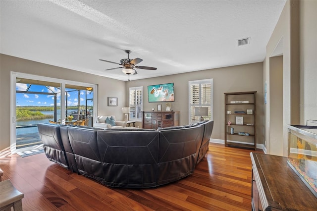 1881 Riveredge Dr, Tarpon Springs, FL 34689 - living room with wood finished floors, ceiling fan, baseboards, a textured ceiling, and a water view