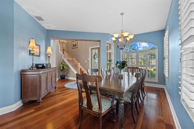 1881 Riveredge Dr, Tarpon Springs, FL 34689 - dining space featuring wood finished floors, a chandelier, stairs, and baseboards