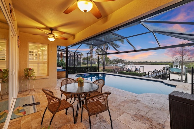 1881 Riveredge Dr, Tarpon Springs, FL 34689 - pool at dusk featuring a water view, a patio, ceiling fan, an outdoor pool, and a dock