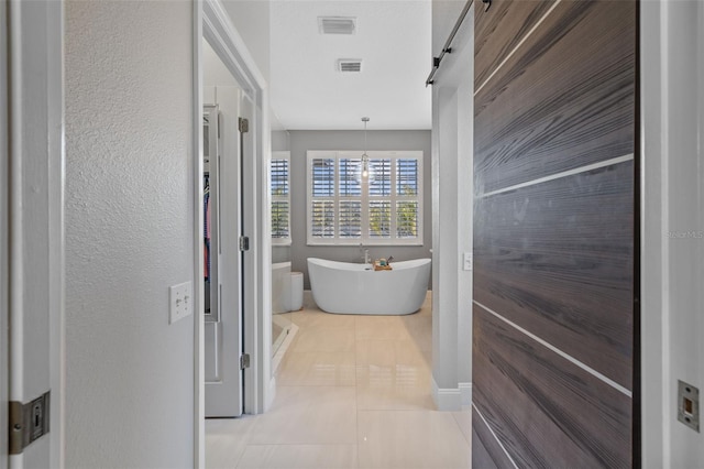 1881 Riveredge Dr, Tarpon Springs, FL 34689 - bathroom featuring a freestanding tub, tile patterned floors, and a textured wall