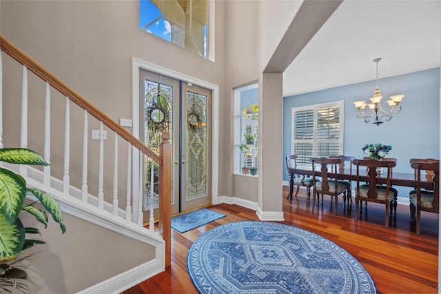 1881 Riveredge Dr, Tarpon Springs, FL 34689 - foyer entrance with stairs, wood finished floors, a chandelier, and baseboards