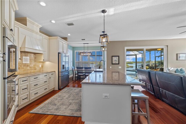 1881 Riveredge Dr, Tarpon Springs, FL 34689 - kitchen with a sink, open floor plan, cream cabinets, decorative backsplash, and dark wood-type flooring