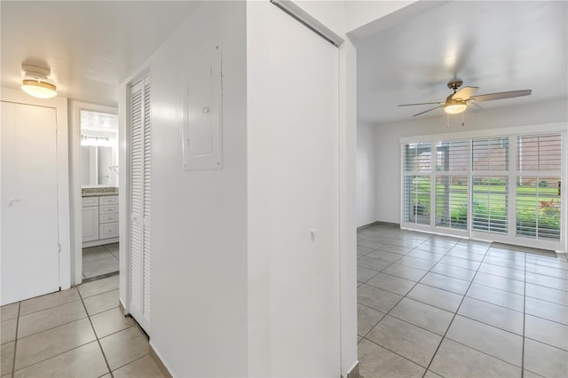 interior space with light tile patterned floors, electric panel, and ceiling fan