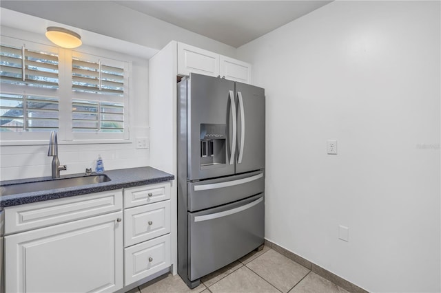 kitchen with light tile patterned floors, sink, stainless steel fridge with ice dispenser, and white cabinets