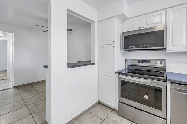 kitchen with white cabinetry, backsplash, light tile patterned flooring, and appliances with stainless steel finishes