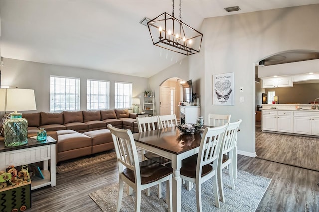 dining space with high vaulted ceiling, dark hardwood / wood-style floors, and sink