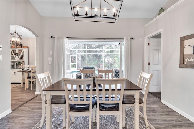 dining area featuring dark wood-type flooring and a notable chandelier