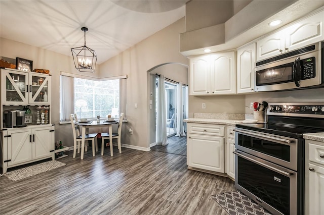 kitchen featuring white cabinetry, appliances with stainless steel finishes, decorative light fixtures, and hardwood / wood-style flooring