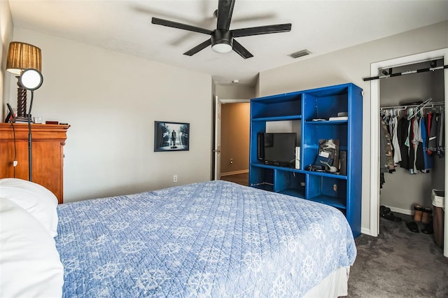 carpeted bedroom featuring ceiling fan and a walk in closet