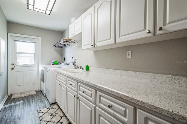 laundry area featuring independent washer and dryer, cabinets, and dark wood-type flooring