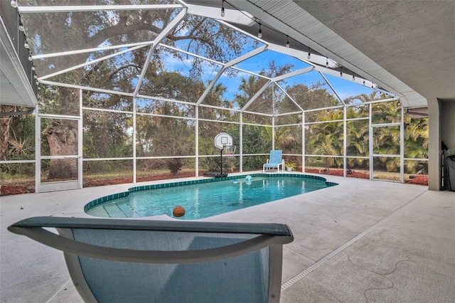 view of swimming pool featuring a patio area and glass enclosure