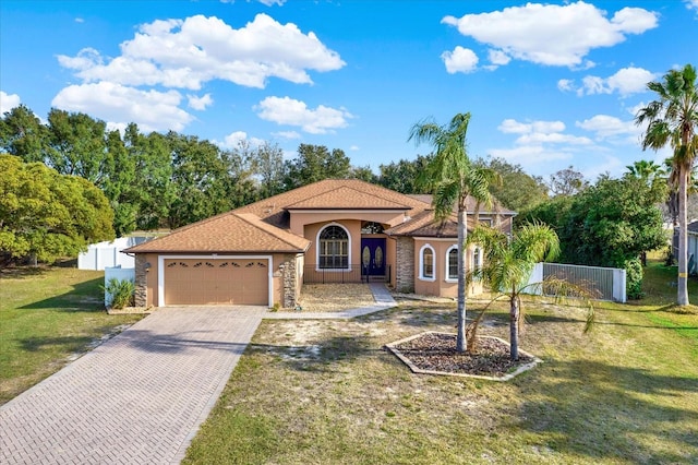 mediterranean / spanish-style house featuring a garage and a front lawn