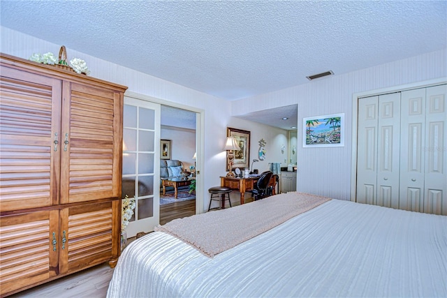 bedroom featuring light hardwood / wood-style floors and a textured ceiling