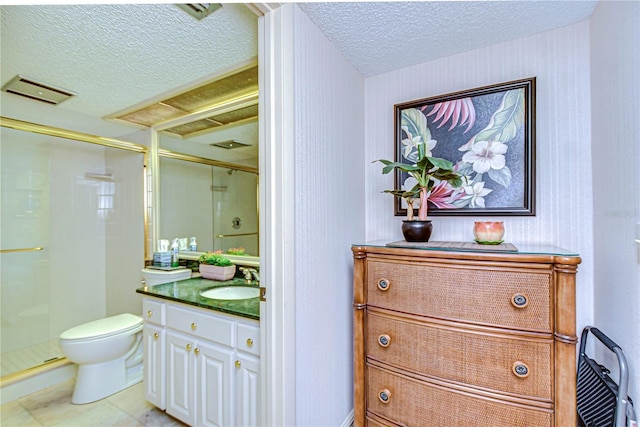 bathroom featuring a shower with door, vanity, a textured ceiling, and toilet