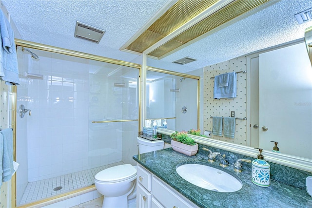 bathroom featuring vanity, toilet, a shower with door, and a textured ceiling