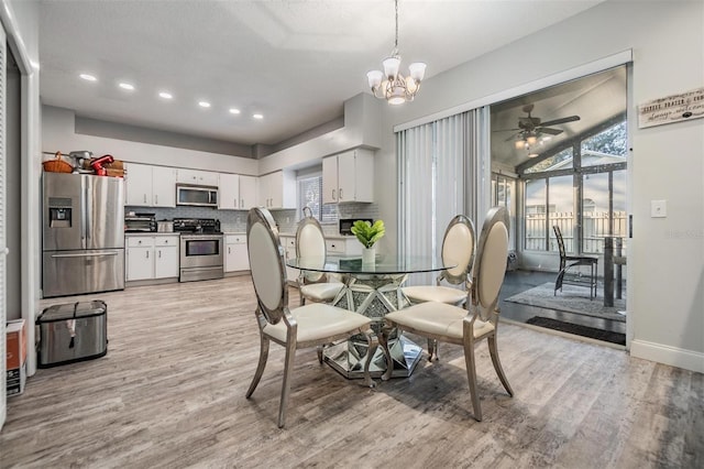 dining area with ceiling fan with notable chandelier and light hardwood / wood-style flooring