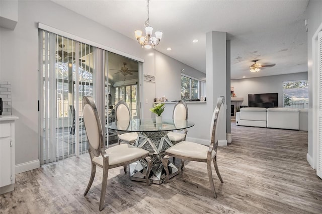 dining space with hardwood / wood-style floors and ceiling fan with notable chandelier