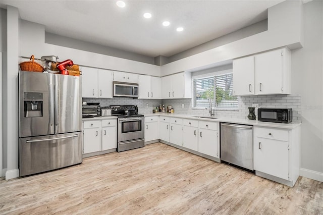 kitchen featuring white cabinetry, sink, backsplash, and stainless steel appliances