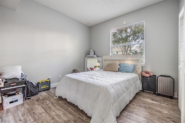 bedroom with hardwood / wood-style floors and a textured ceiling