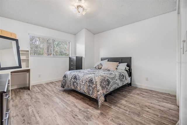 bedroom with hardwood / wood-style floors and a textured ceiling